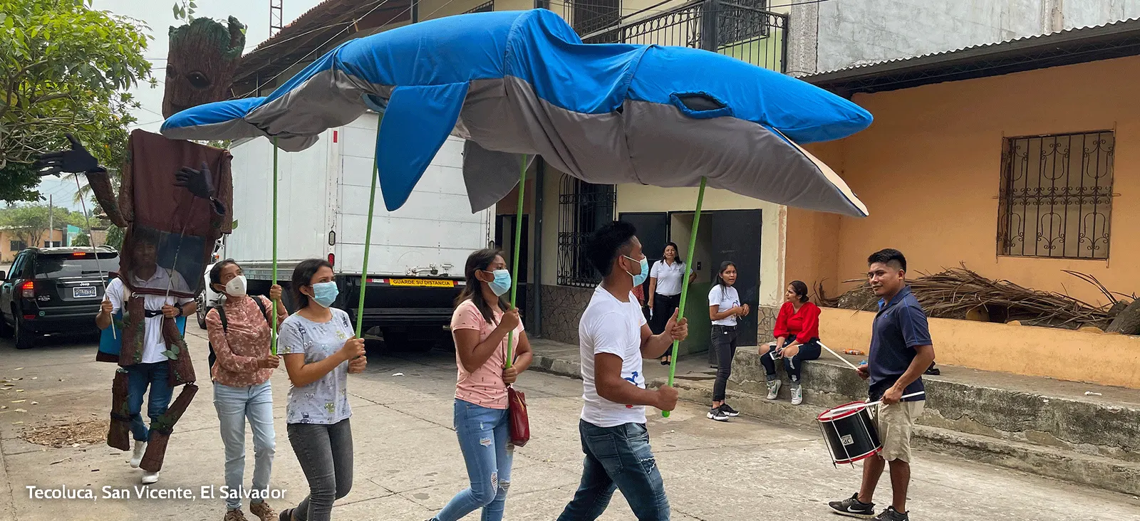 Juventudes de Tecoluca, San Vicente, en un pasacalle ambiental con una figura de tiburón